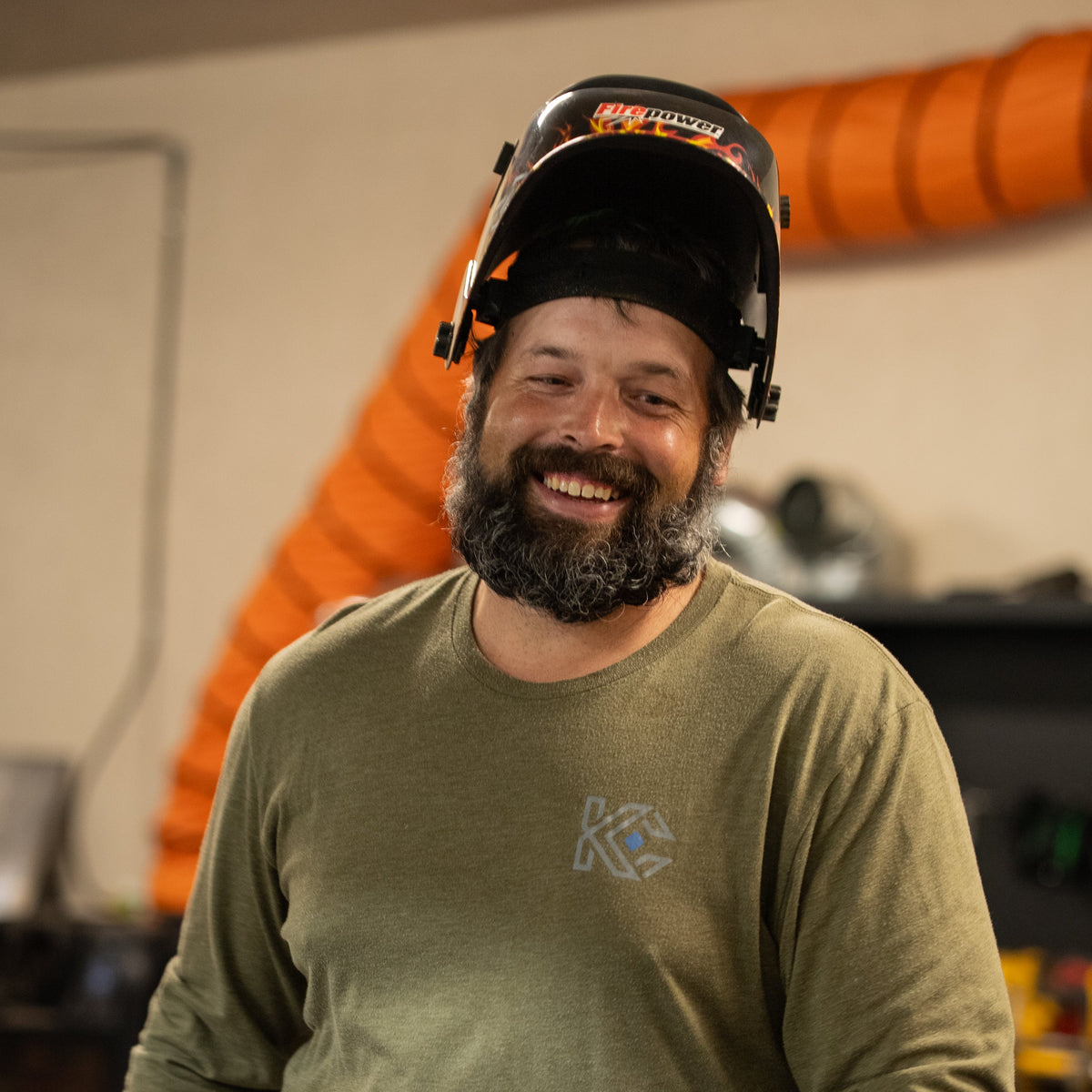 Man wearing a helmet and gloves in an industrial setting